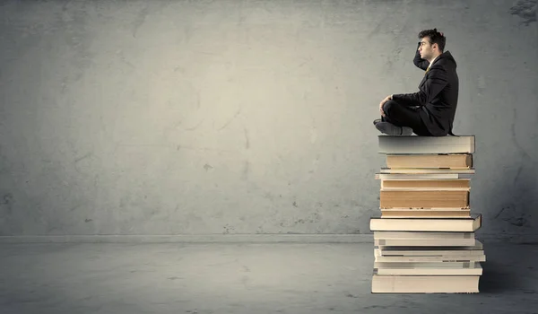 Estudante sentado na pilha de livros — Fotografia de Stock