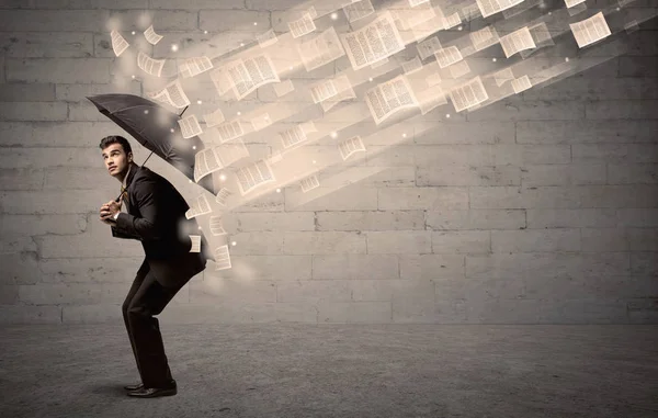 Zakenman met paraplu tegen wind van papieren bescherming — Stockfoto