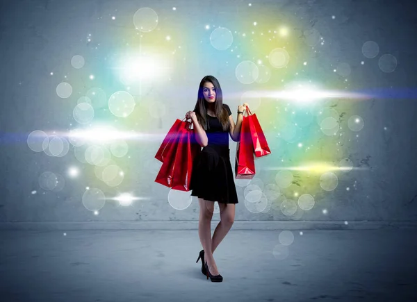 쇼핑백과 반짝 이는 불빛을 가지고 있는 여자 — 스톡 사진