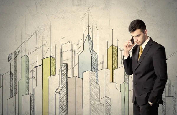 Businessman standing with drawn cityscape — Stock Photo, Image