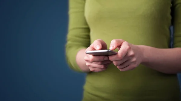 Mujer joven sosteniendo el teléfono inteligente en la mano —  Fotos de Stock