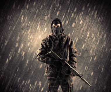 Yağmurlu arka plan üzerinde Maskeli silahlı terörist adam