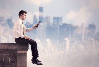 Yüksek bir binanın tepesinde oturan satıcı.