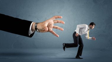 İş adamı büyük bir el kavramından kaçıyor.