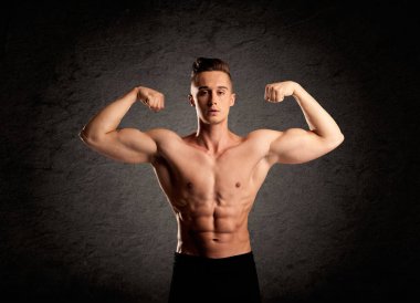Seksi halterci adam kaslarını gösteriyor.