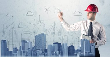 Genç işçi şehir manzarası çiziyor.