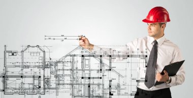Genç bir mimar ev planı çiziyor.