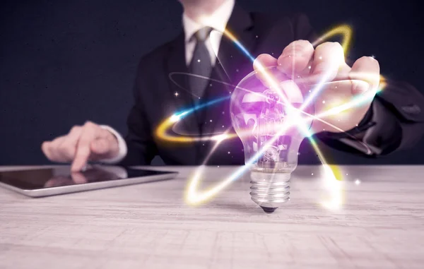 Businessman holding a colorful light bulb — Stock Photo, Image