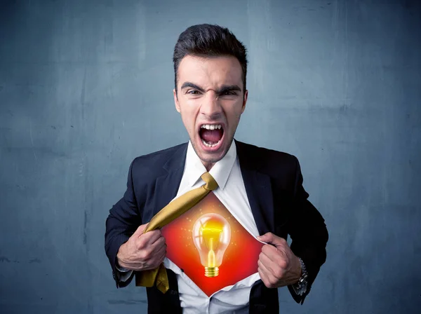 Businessman ripping off shirt and idea light bulb appears — Stock Photo, Image