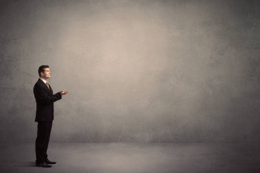 Boş bir duvarın önünde, ayakta işadamı