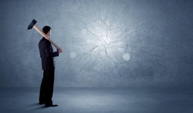 İşadamı çekiçle duvara çarpıyor.