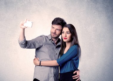 Mutlu çift temiz duvarlı selfie çekiyor.
