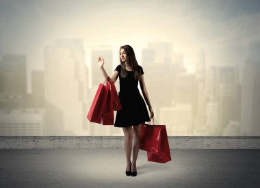 Alışveriş torbalarıyla duran şehir kadını.