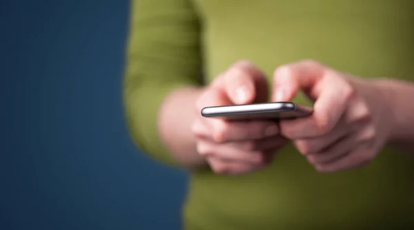 Mladá žena drží chytrý telefon v ruce — Stock fotografie