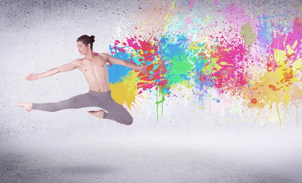 Moderne street danser springen met kleurrijke verf spatten — Stockfoto