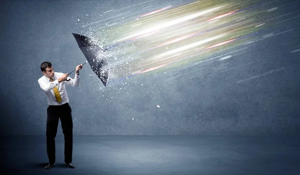 Homme d'affaires défendant les faisceaux lumineux avec concept de parapluie — Photo