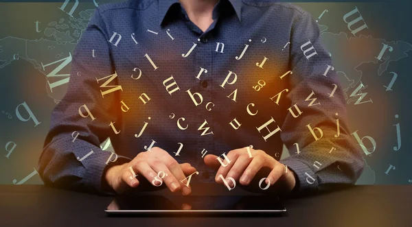Man typing in formal clothing and letters around