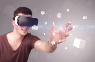 Adam sanal gerçeklik gözlüğü takıyor.