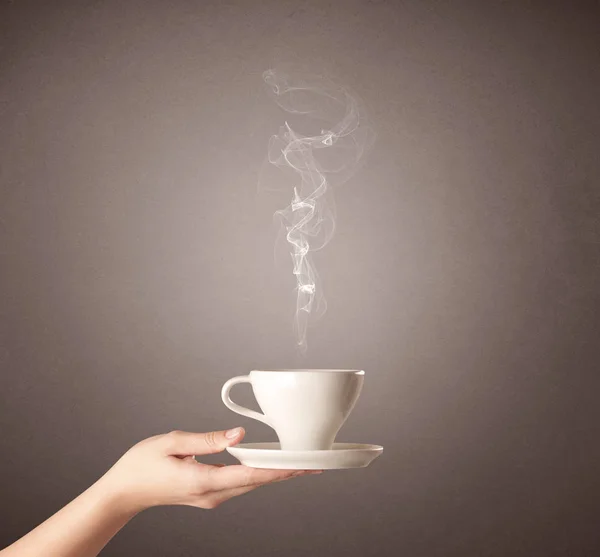 Vrouwelijke hand bedrijf koffie beker — Stockfoto