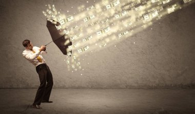 İş adamı dolar yağmuruna karşı şemsiye tutuyor