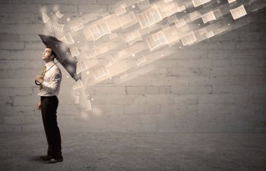 İş adamı ile şemsiye kağıtları rüzgara karşı koruma