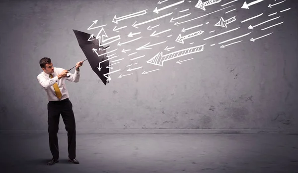 Business man standing with umbrella and drawn arrows hitting him — Stock Photo, Image