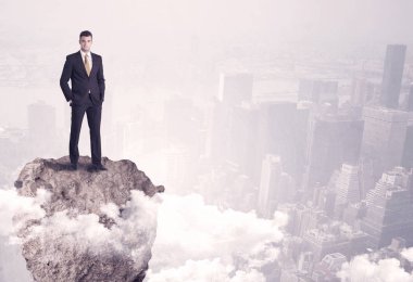 Kayanın üzerinde duran kazanan iş kişi