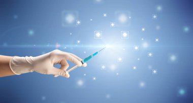 Kadın doktor elinde şırınga tutuyor.