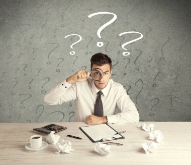 İş adamı soru işaretiyle masada.