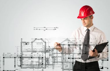 Genç bir mimar ev planı çiziyor.
