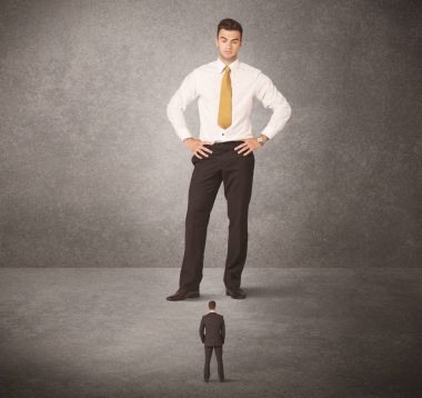 Büyük iş adamı küçük işçilere bakıyor.