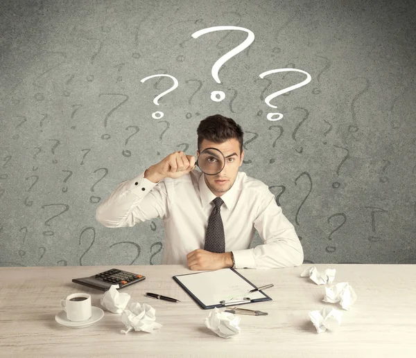 İş adamı soru işaretiyle masada.
