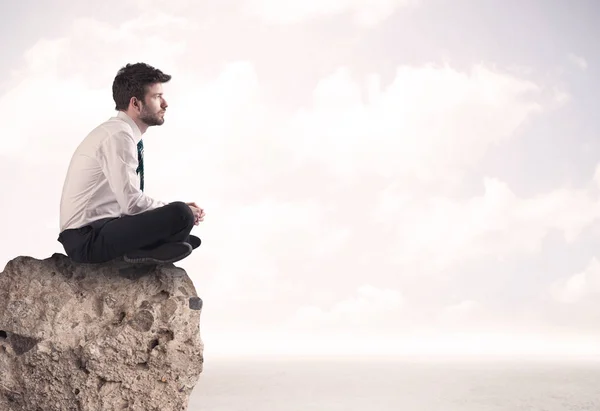 Business man sitting on stone edge — Stock Photo, Image