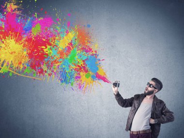 Kamera ve boya sıçratan hippi adam.