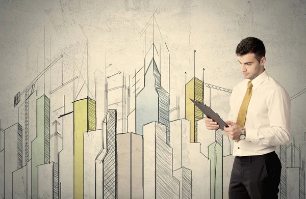 Businessman standing with drawn cityscape — Stock Photo, Image