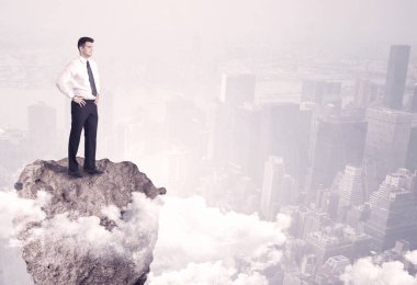 Kayanın üzerinde duran kazanan iş kişi