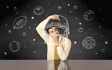 İş adamı miğfer ve spor topu çiziyor.