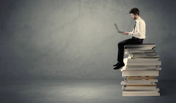 Étudiant assis sur une pile de livres — Photo