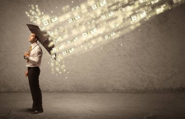İş adamı dolar yağmuruna karşı şemsiye tutuyor