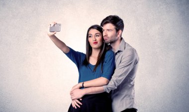 Mutlu çift temiz duvarlı selfie çekiyor.
