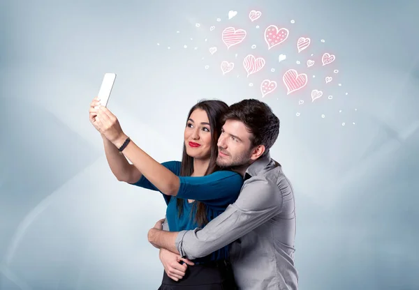 Pár zamilovaný brát selfie s červeným srdcem — Stock fotografie