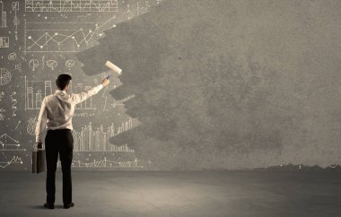 Satış elemanı duvardaki tabloların üstünü boyuyor.