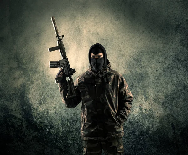 Portrait of a heavily armed masked soldier with grungy backgroun — Stock Photo, Image