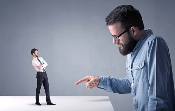 Giovane uomo d'affari che lotta con uomo d'affari in miniatura — Foto Stock