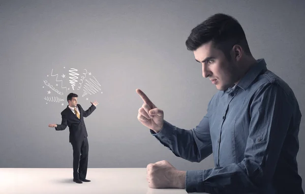 Young businessman fighting with miniature businessman — Stock Photo, Image