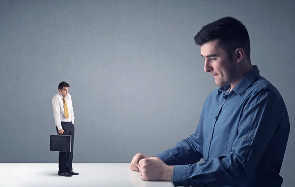 Joven hombre de negocios luchando con empresario en miniatura —  Fotos de Stock