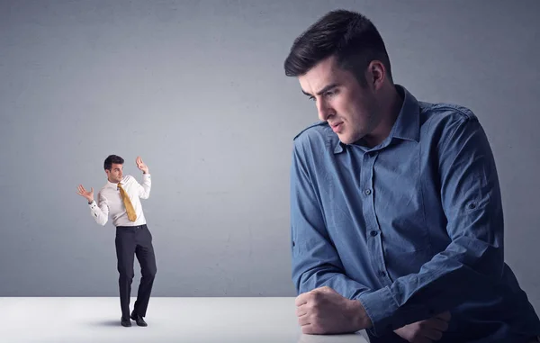 Young businessman fighting with miniature businessman — Stock Photo, Image