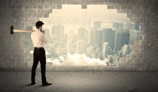 Hombre de negocios golpeando la pared con martillo en la vista de la ciudad — Foto de Stock