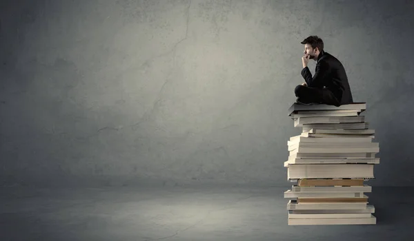 Homem elegante sentado em livros — Fotografia de Stock