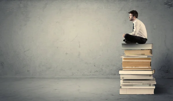 Student sitting on stack of books Royalty Free Stock Photos